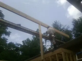 Carpenter setting a ridge beam over a new addition frame — Ice Dam Removal by Roofing Brothers in Timberville