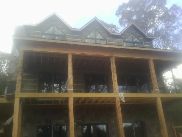 Dormers and porch framing on a large log home under construction in Timberville