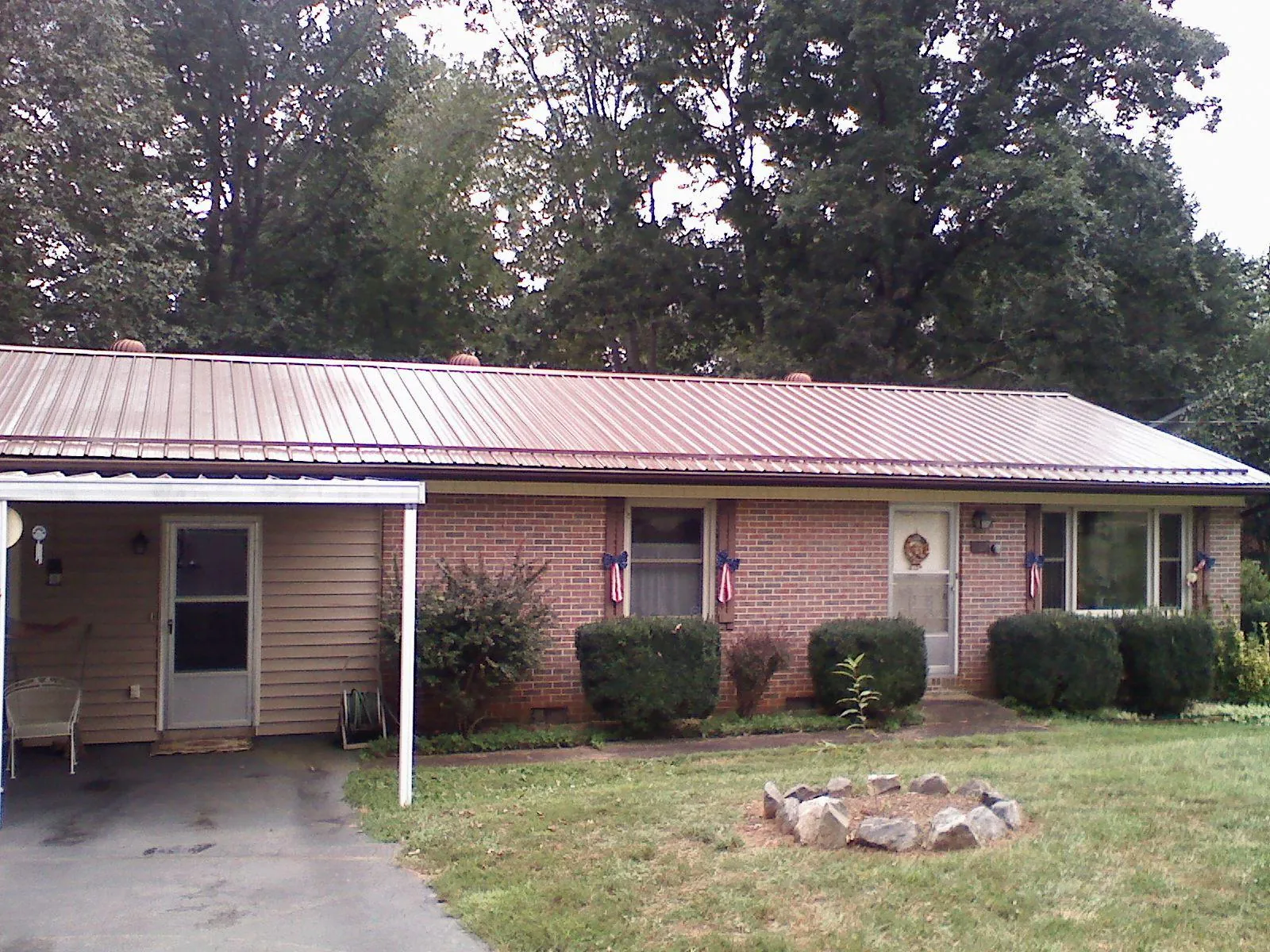 Bronze metal roof and carport on a brick ranch home — Roof Repair work by our crew in Timberville