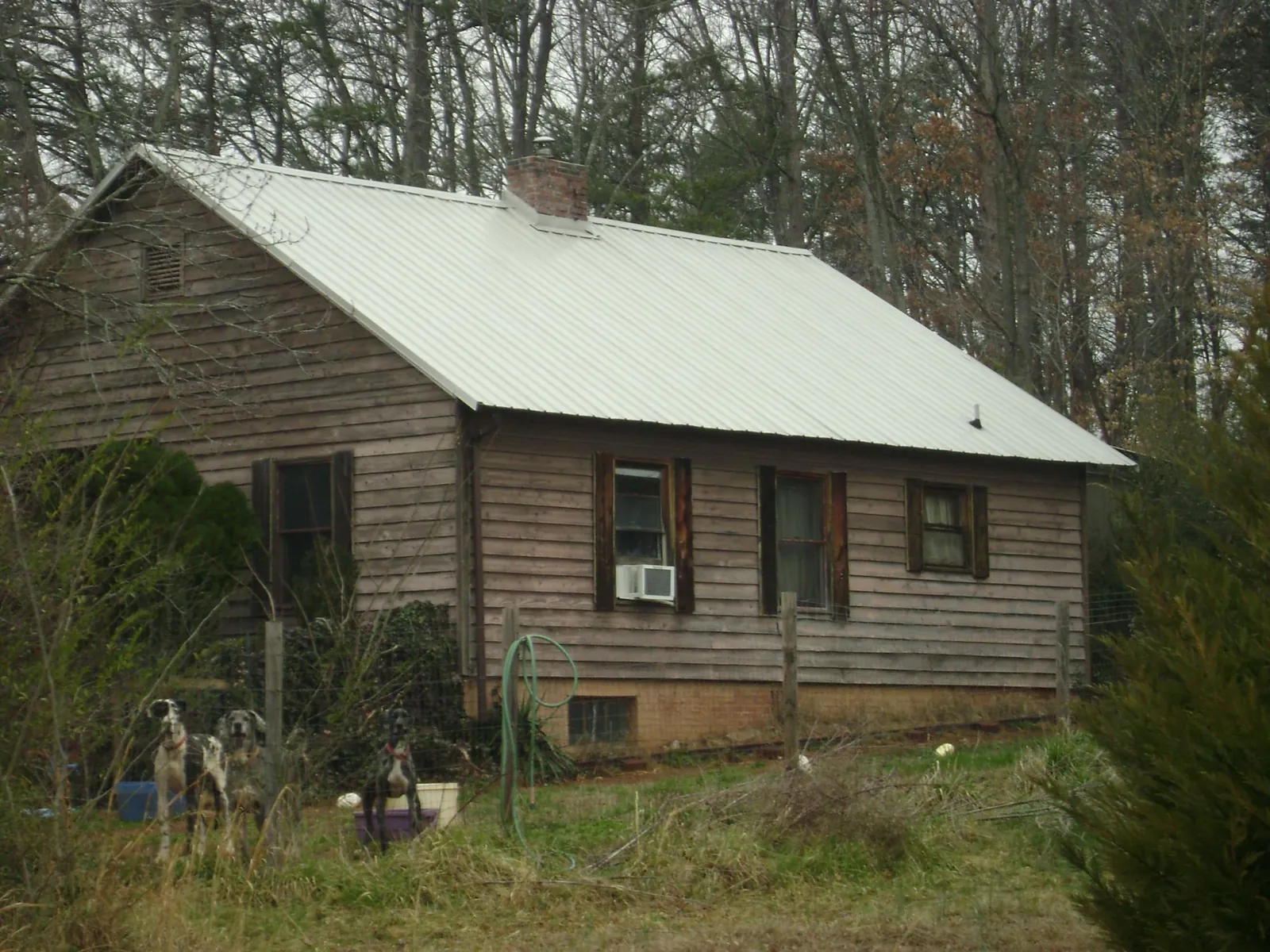 White metal roof on an old wood sided farmhouse, from a Metal Roof Installation job in Timberville